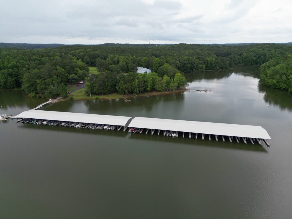 Aerial view of two new covered floating docks with gable roofs at Highland Pines Marina on West Point Lake, LaGrange, Georgia
