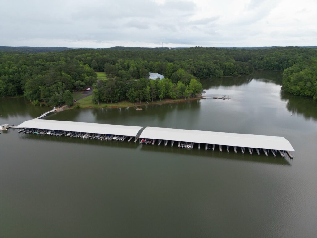 Aerial view of two new covered floating docks with gable roofs at Highland Pines Marina on West Point Lake, LaGrange, Georgia