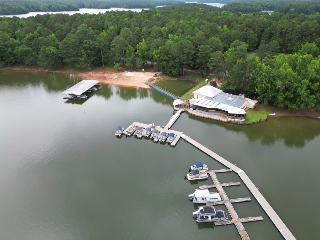 Aerial view of two new covered floating docks with gable roofs at Highland Pines Marina on West Point Lake, LaGrange, Georgia