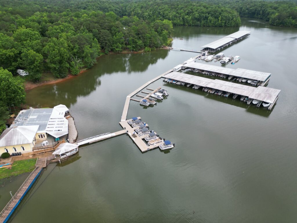 Aerial view of two new covered floating docks with gable roofs at Highland Pines Marina on West Point Lake, LaGrange, Georgia