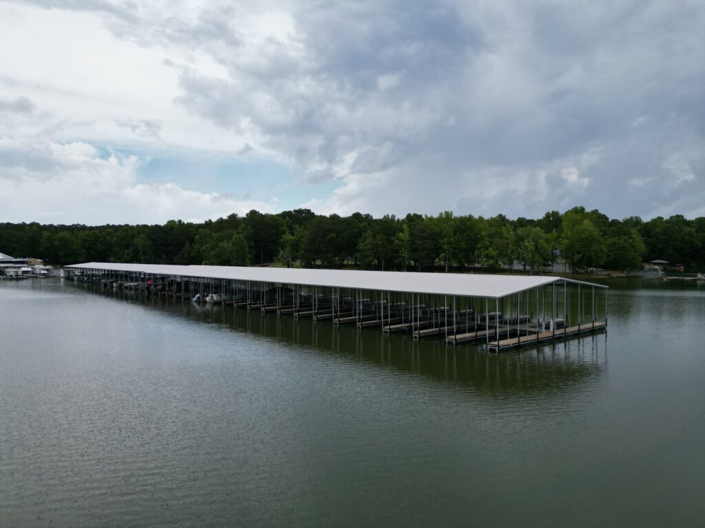 Aerial view of two new covered floating docks with gable roofs at Highland Pines Marina on West Point Lake, LaGrange, Georgia