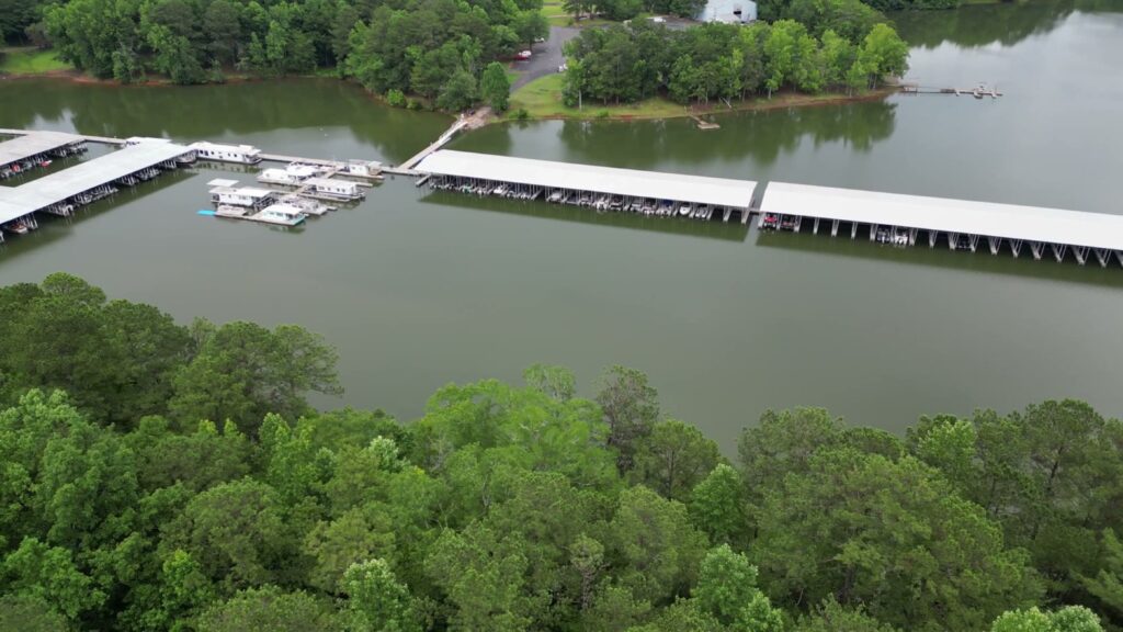 Aerial view of two new covered floating docks with gable roofs at Highland Pines Marina on West Point Lake, LaGrange, Georgia