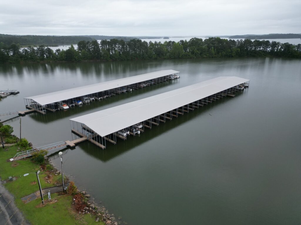 Aerial view of two new covered floating docks with gable roofs at Southern Harbor Marina on West Point Lake, Lanett, Alabama